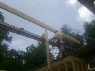 Carpenter setting a ridge beam over a new addition frame — Ice Dam Removal by Roofing Brothers in Upperstrasburg