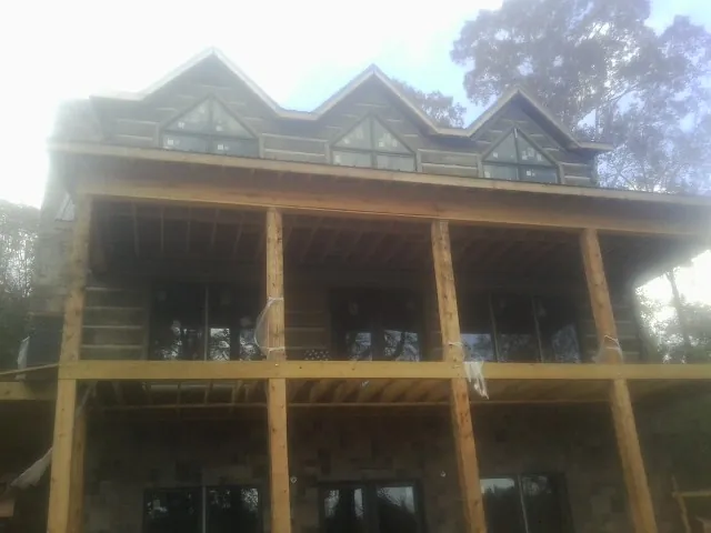 Dormers and porch framing on a large log home under construction — Roof Coating work by our crew in Upperstrasburg