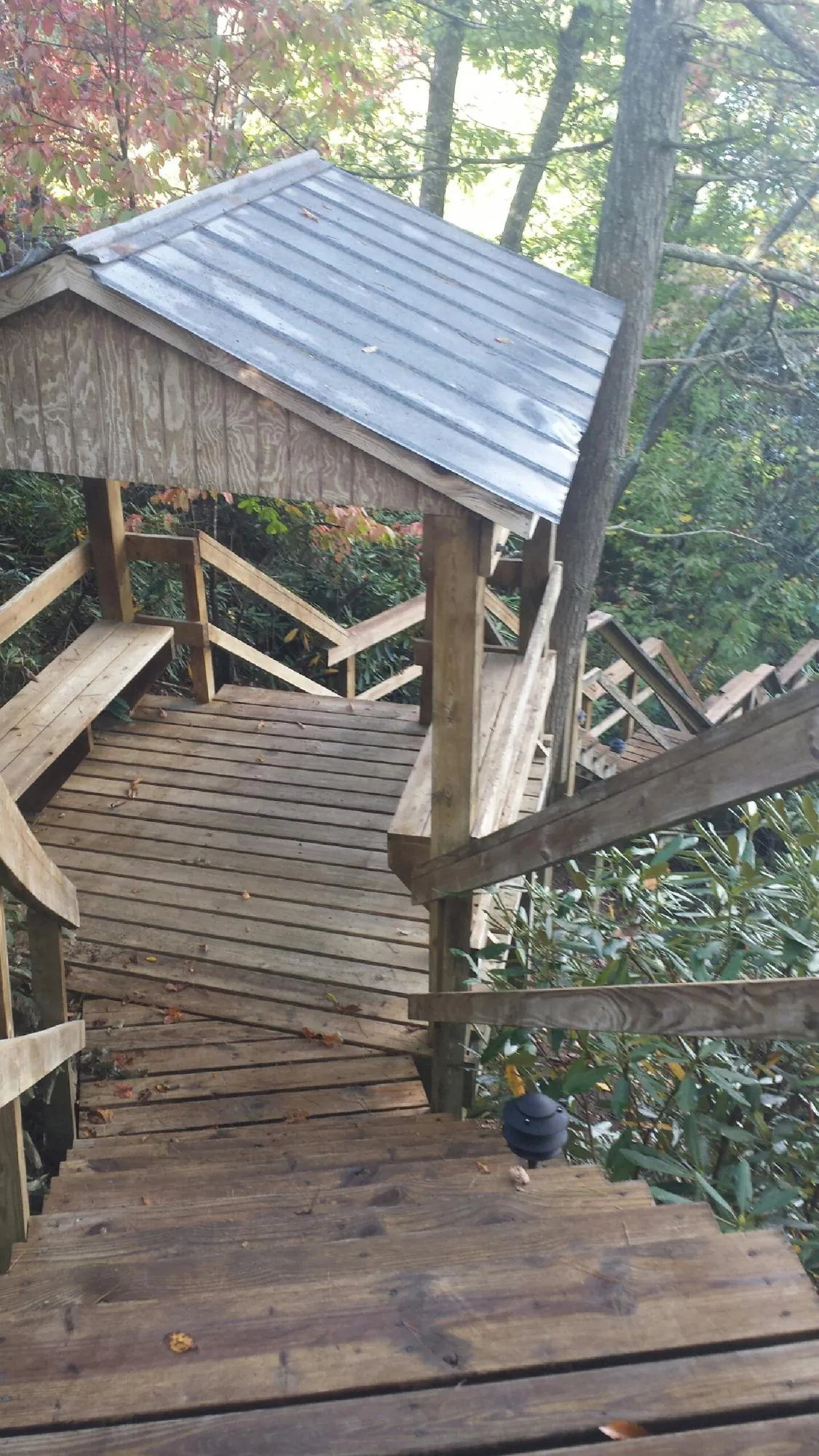 Metal roofed shelter over wooden steps on a wooded walkway — Skylight Repair & Installation work by our crew in Upperstrasburg